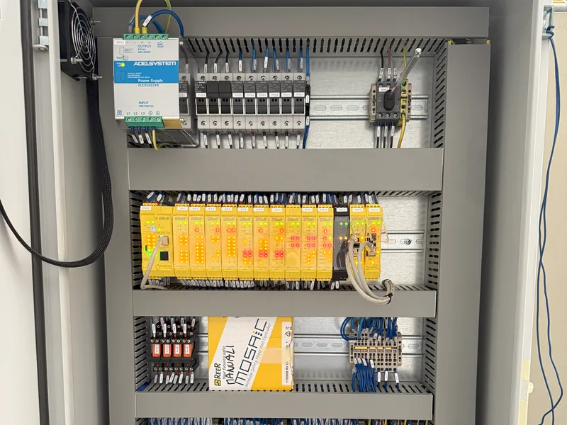 Quadro delle sicurezze aperto: PLC di sicurezza ReeR Mosaic, alimentatore Adel System e morsettiere