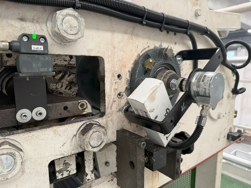 Encoder di sicurezza montato su un rullo, con il sensore di una protezione a sinistra