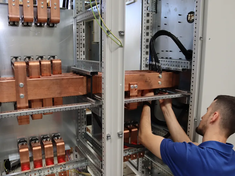 Un nostro tecnico collega i cavi di potenza sotto le barre del quadro